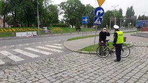 Policjant prowadzi rozmowę z rowerzystą.