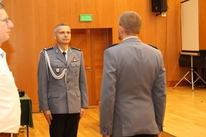 zastępca komendanta wojewódzkiego policji przyjmuje od innego policjanta meldunek o zakończeniu uroczystości