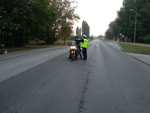Motocyklista badany przez policjanta na zawartość alkoholu.