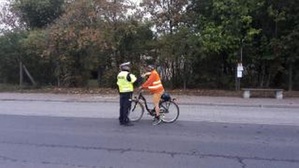 Kolejny cyklista jest sprawdzany przez policjanta WRD.