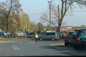 Policjantka stoi na skrzyżowaniu i kieruje ruchem.