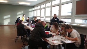 Policjantka w Sztabie WOŚP w Inowrocławiu. W pomieszczeniu wolontariusze przekazują zebrane pieniądze, a pracownicy sztabu przyjmują je do rozliczenia