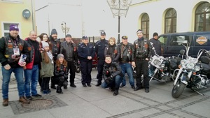 Policjantka i policjanci stoją wśród wolontariuszy WOŚP - członków klubu motocyklowego Riders Club Inowrocław. Widoczne również motocykle członków klubu.