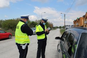 Policjanci rozmawiają z zatrzymanym kierowcą
