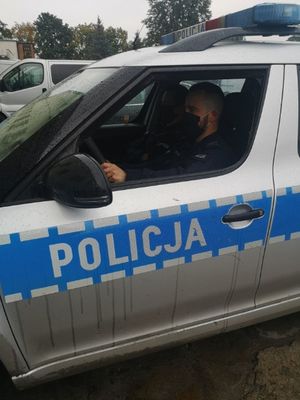 Policjant w maseczce siedzi w radiowozie