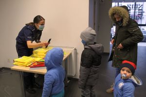 dzieci przy policyjnym stoisku otrzymują odblsaki