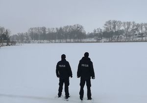 Policjanci patrolują z brzegu zamarznięte Jezioro Gopło